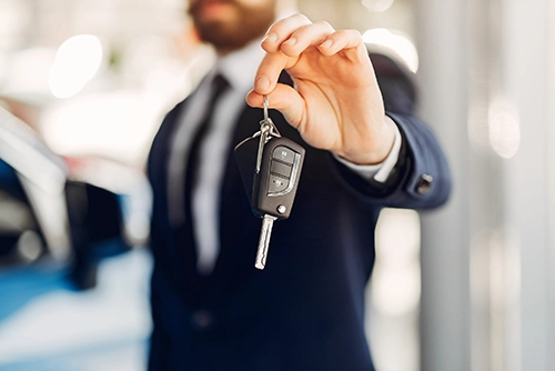 Un homme tend une clé de voiture pour restituer un véhicule