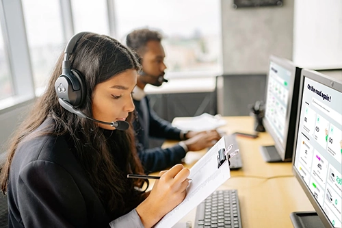 femme et homme travaillent sur ordinateurs. Ils utilisent un logiciel de gestion de flotte