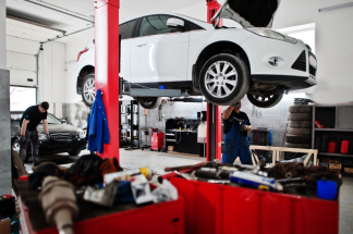 Un garagiste gère l''entretien d'une voiture qui est suspendue en hauteur