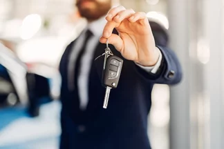 Un homme tend une clé de voiture pour restituer un véhicule