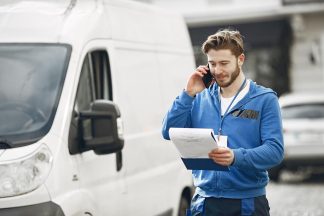 Homme livreur à coté d'une camionnette